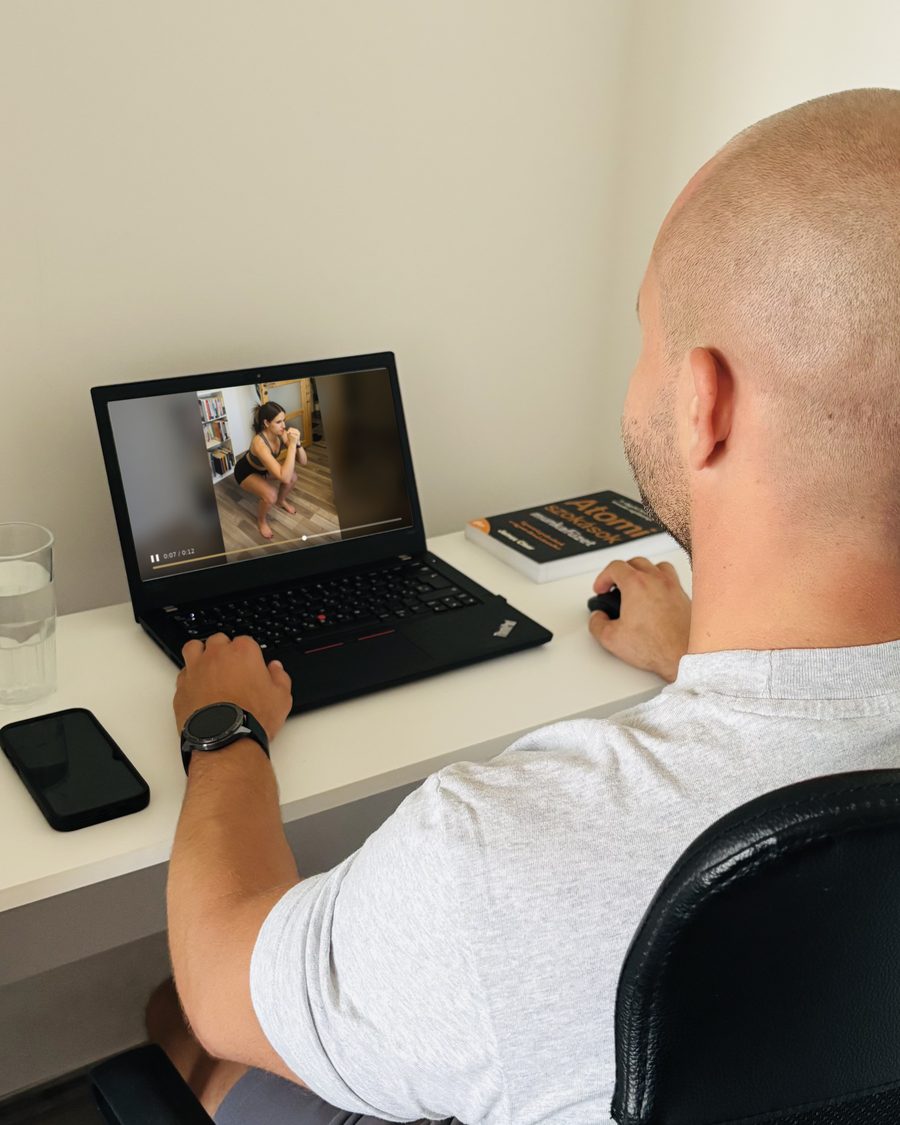 Szabó Gábor a laptopján egy ügyfél guggolásáról készült videót néz át